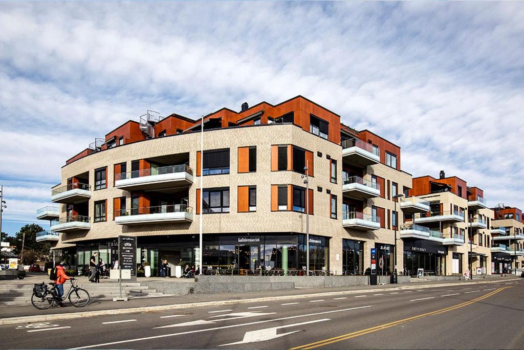 2 bedroom Apartment close to city centre and beach في أوسلو: مبنى على جانب شارع مع شخص على دراجة