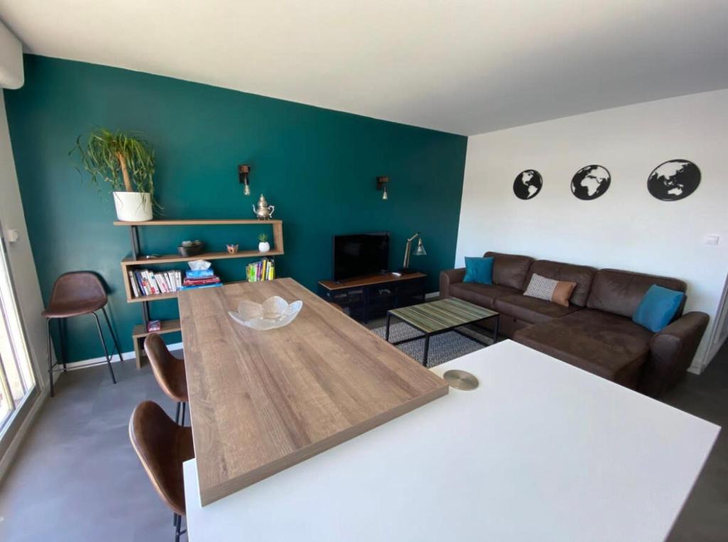 un salon avec une table et un canapé dans l'établissement Vue sur les toits de Tours, à Tours