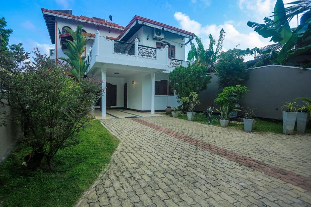 a white house with a brick driveway at Villa Sun Grace in Galle