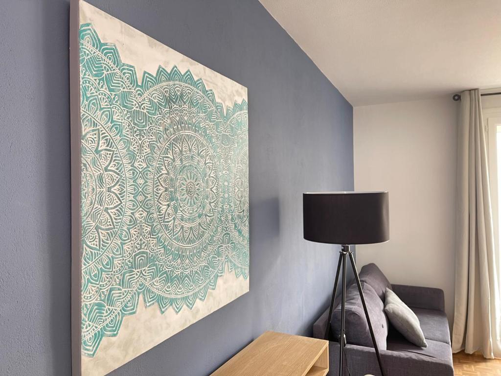 une peinture accrochée à un mur à côté d'une lampe dans l'établissement Grand appartement cosy 4ch, à Cholet