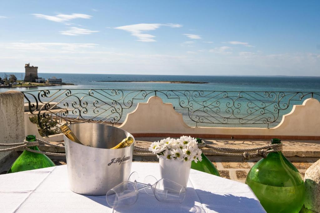 a table with glasses and flowers and a view of the ocean at Villa Gaudì - Mallorca in Sant'Isidoro