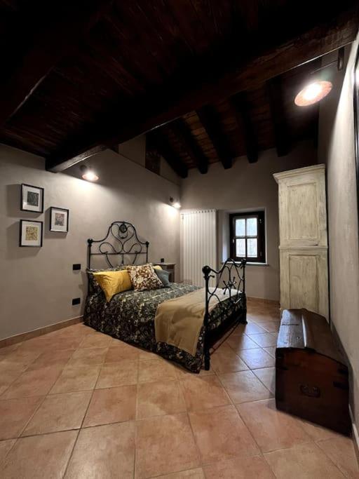a bedroom with a bed and a bench in a room at La Grangia in Giaveno