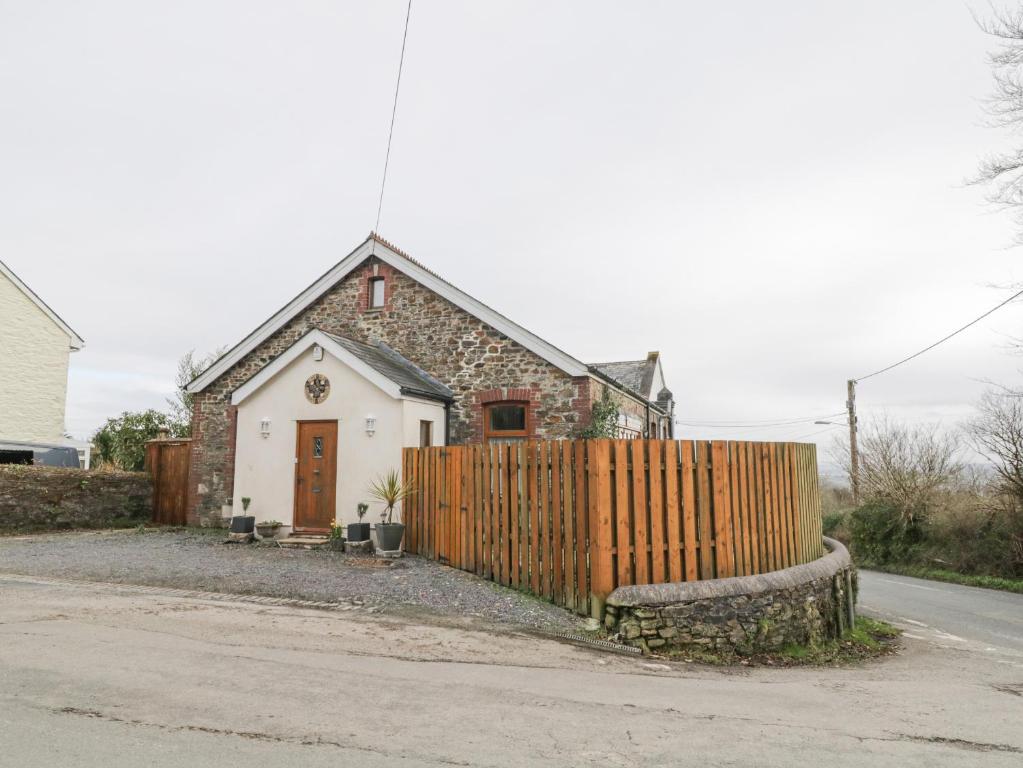 una casa con una valla de madera delante de ella en The Old Sunday School, en Gunnislake