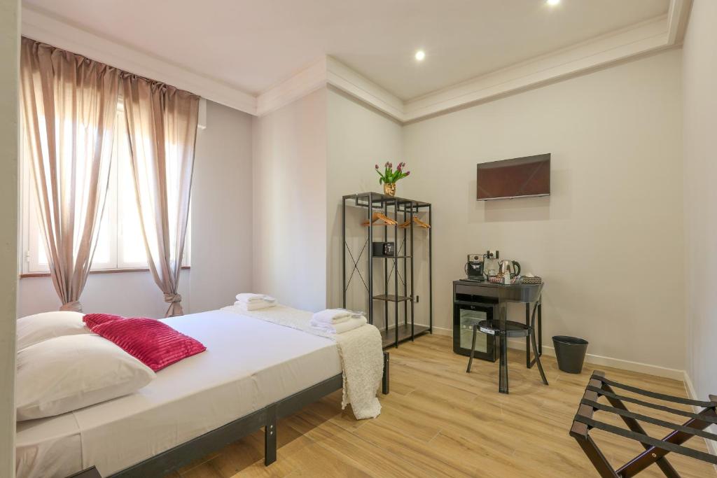 a white bedroom with a bed and a desk at Cuore Napoli Centro in Naples