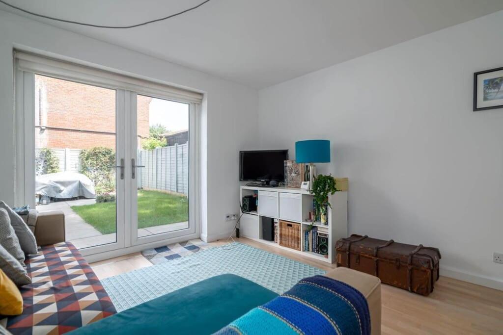 uma sala de estar com um sofá e uma grande janela em 2BD House Canal View and Garden em Londres