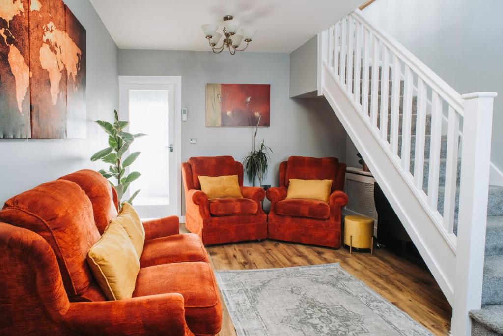 a living room with two chairs and a staircase at No.10 Bristol in Bristol