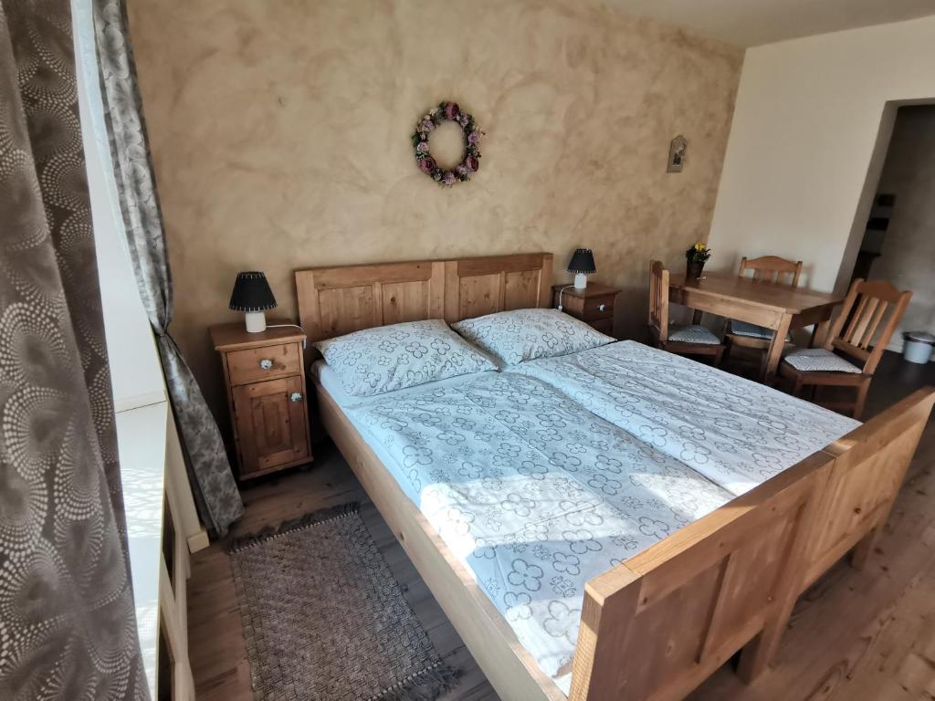 een slaapkamer met een houten bed en een tafel bij Apartmány U Koudelníka in Kutná Hora