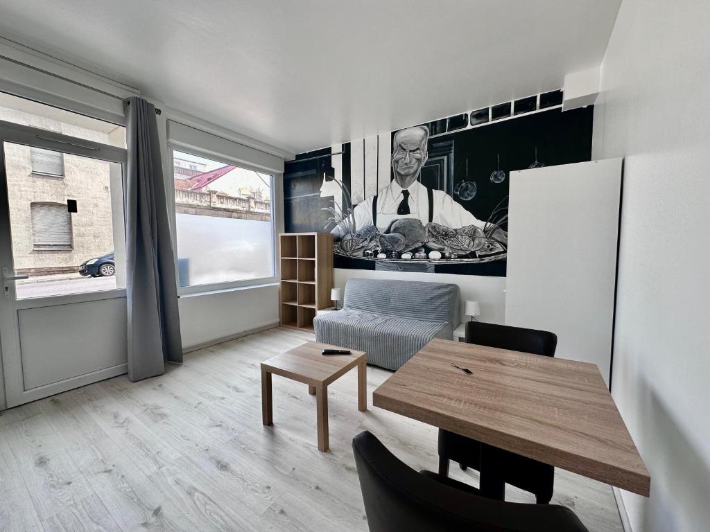 un salon avec une table et une photo d'un serveur dans l'établissement 01 Studio Immeuble Le GD, à Jarny