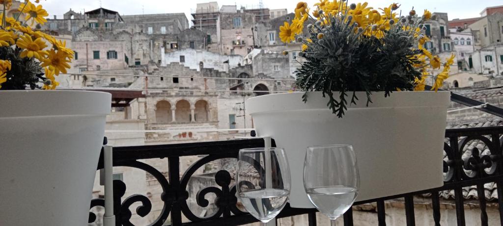 balcone con bicchieri da vino e vista sulla città di Radici - La finestra sui Sassi a Matera