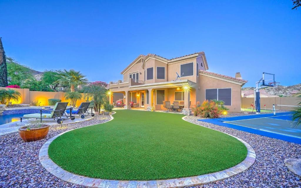 una casa con césped y piscina en Desert Paradise Pool Spa Pickleball Putt Green en Phoenix