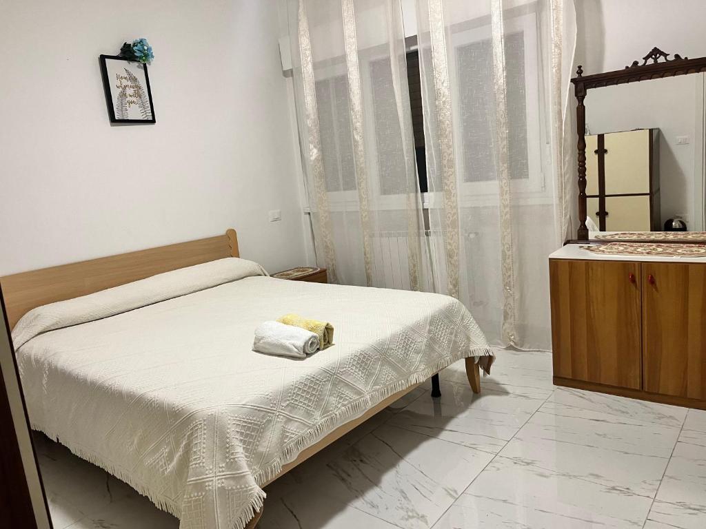 Un dormitorio con una cama con una toalla. en Camere in appartamento condiviso, vista sulla città en Udine