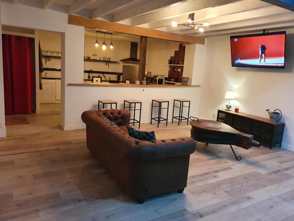ein Wohnzimmer mit einem Sofa und einem Flachbild-TV in der Unterkunft Maison de campagne in Amponville