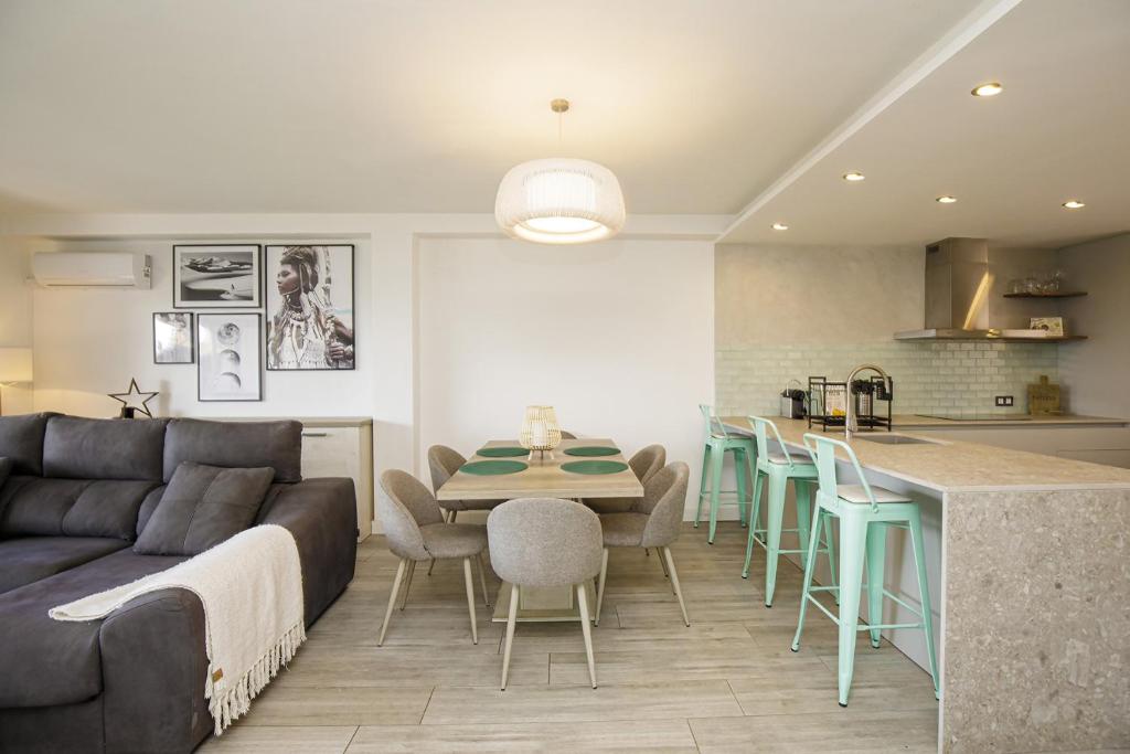 een keuken en een woonkamer met een bank en een tafel bij Casa con bonitas vistas en Montjuic Girona in Girona