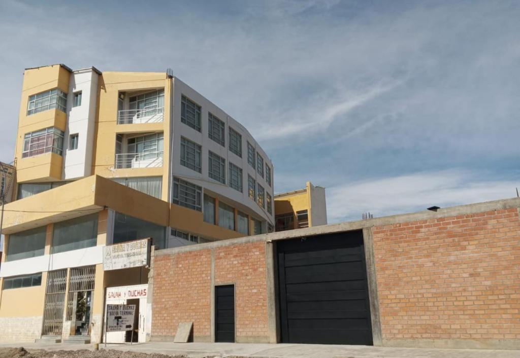 un edificio de ladrillo con un garaje delante de él en The Oruro Inn, en Oruro