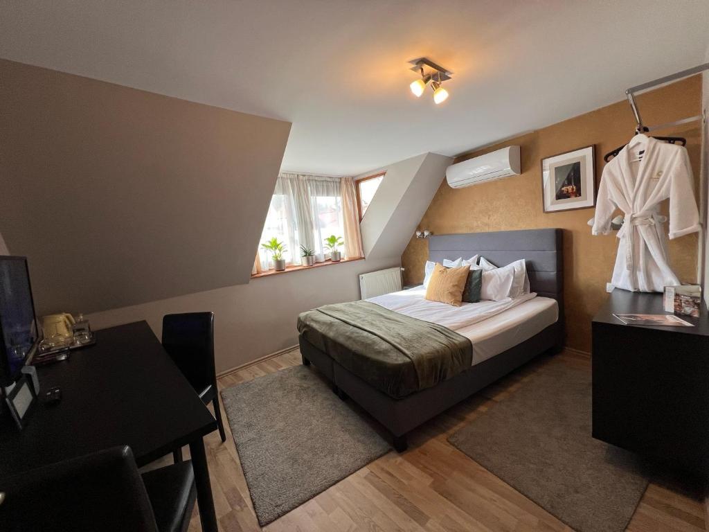 a bedroom with a bed with a robe hanging on the wall at Margaréta Garden & SPA in Eger