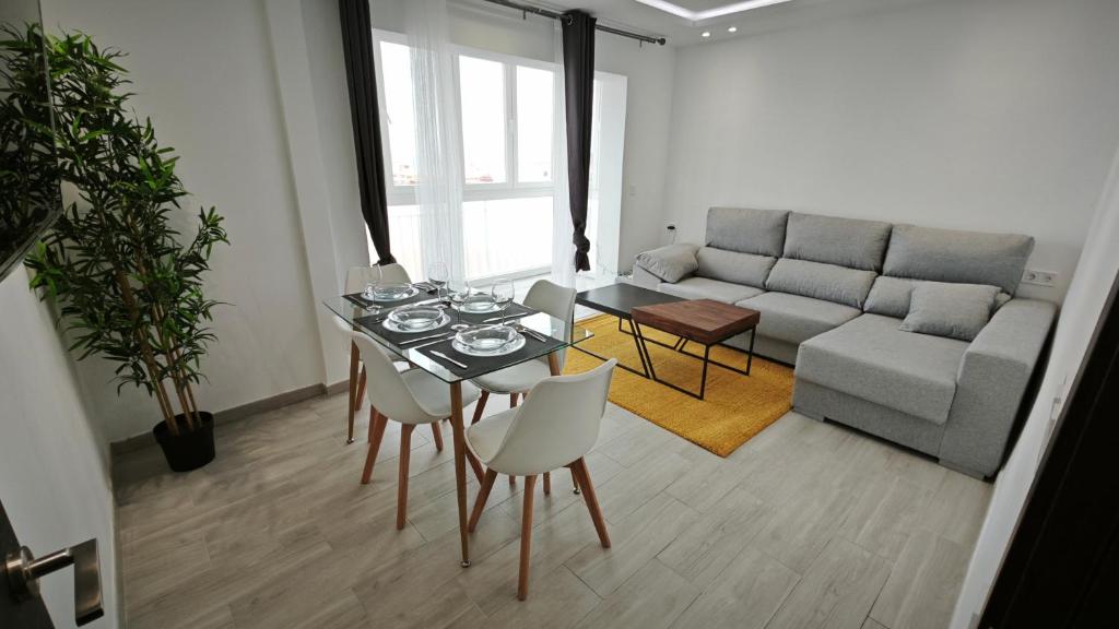 sala de estar con mesa y sofá en Vialia Playa, en Málaga