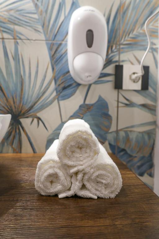 a pile of towels on a table with a roll of paper towel at Cuore Napoli Centro in Naples