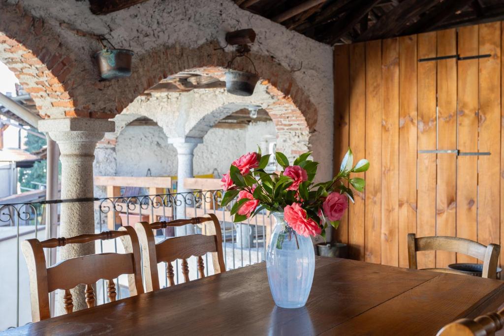 un vase de fleurs assis sur une table en bois dans l'établissement Dal Picasass House, à Madonna del Sasso