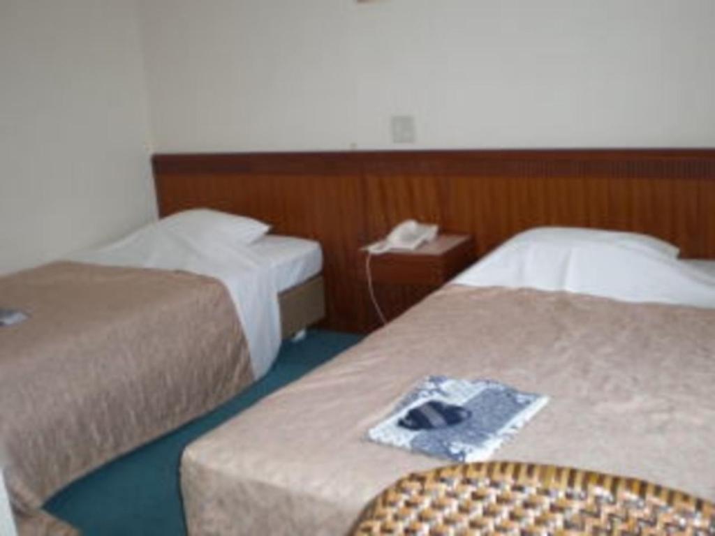 una habitación de hotel con 2 camas y una silla en Kikai Daiichi Hotel - Vacation STAY 30332v, 