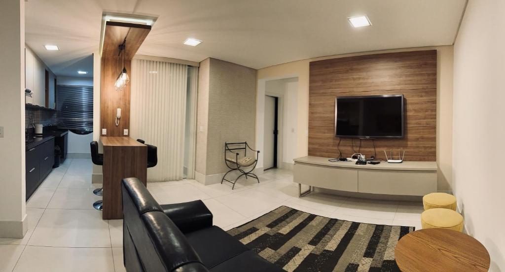 sala de estar con sofá y TV en Gontijo Apart Hotel en Itajubá