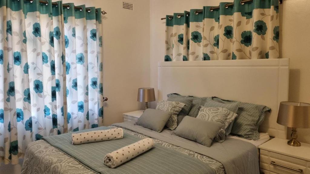 una camera con un letto con due cuscini sopra di Modern and Stylish 2-Bed Cottage in Harare a Harare