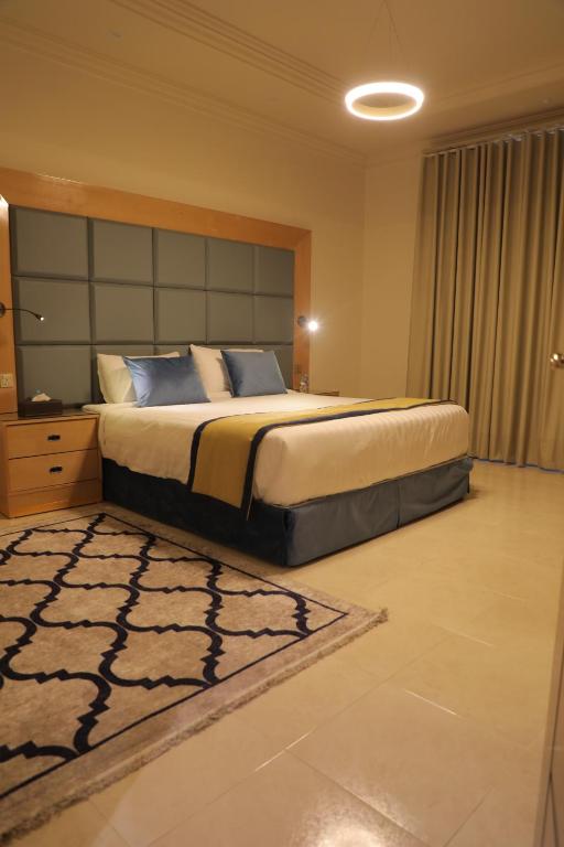 a bedroom with a large bed and a rug at SAVOY APARTMENTS in Taif