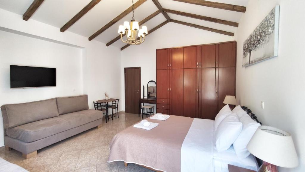 a bedroom with a bed and a couch at Oasis Apartment Ammoudia in Ammoudia