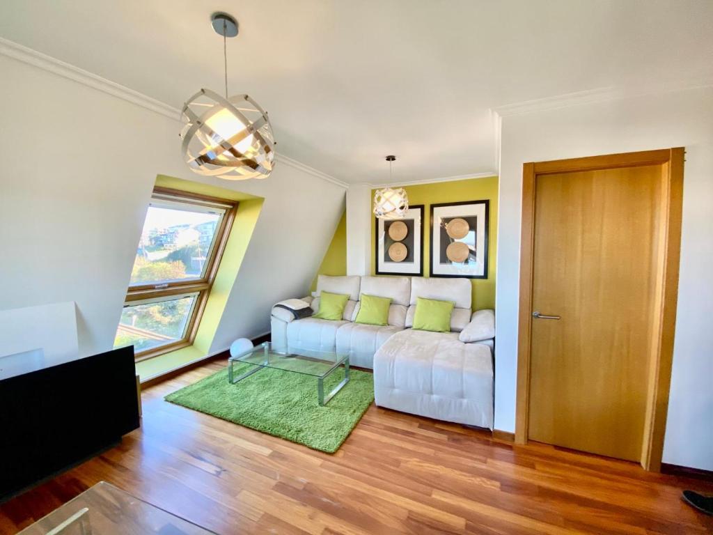 ein Wohnzimmer mit einem Sofa und einem Fenster in der Unterkunft Ático Deluxe San Ciprian in San Cibrao