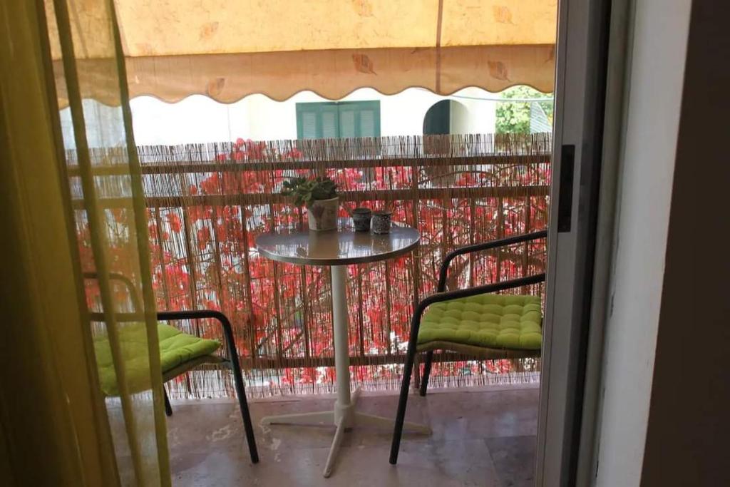 uma mesa e duas cadeiras numa varanda em Cozy double apartment near the sea em Tolo