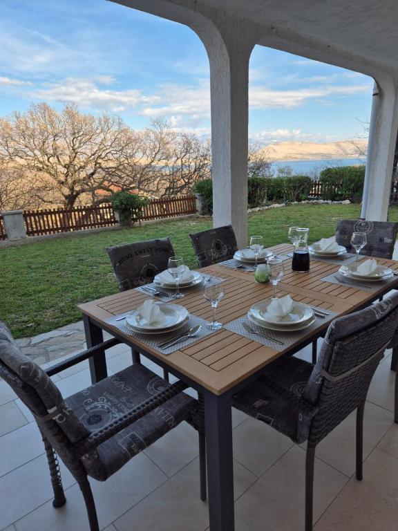 a wooden table sitting on a porch with chairs and a tableablish at Pag House in Pag