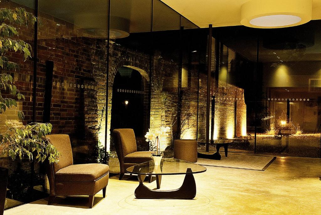 a lobby with a table and chairs and a brick wall at Lifehouse Spa And Hotel in Frinton-on-Sea