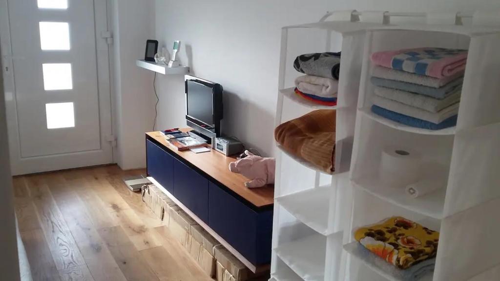 Habitación con escritorio y estante con TV. en Monteurshaus Kalenberg ein Bett Zimmer, en Mechernich