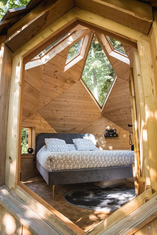 - une chambre dans une cabane en rondins avec un lit dans l'établissement Bulles d'Olive Zome Céleste - Piscine & Jacuzzi avec vue, à Nyons