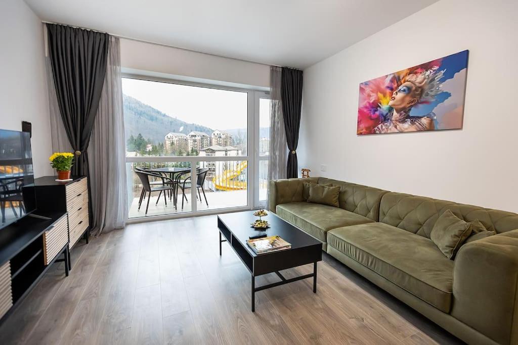 a living room with a couch and a table at Royal Family Apartment in Sinaia