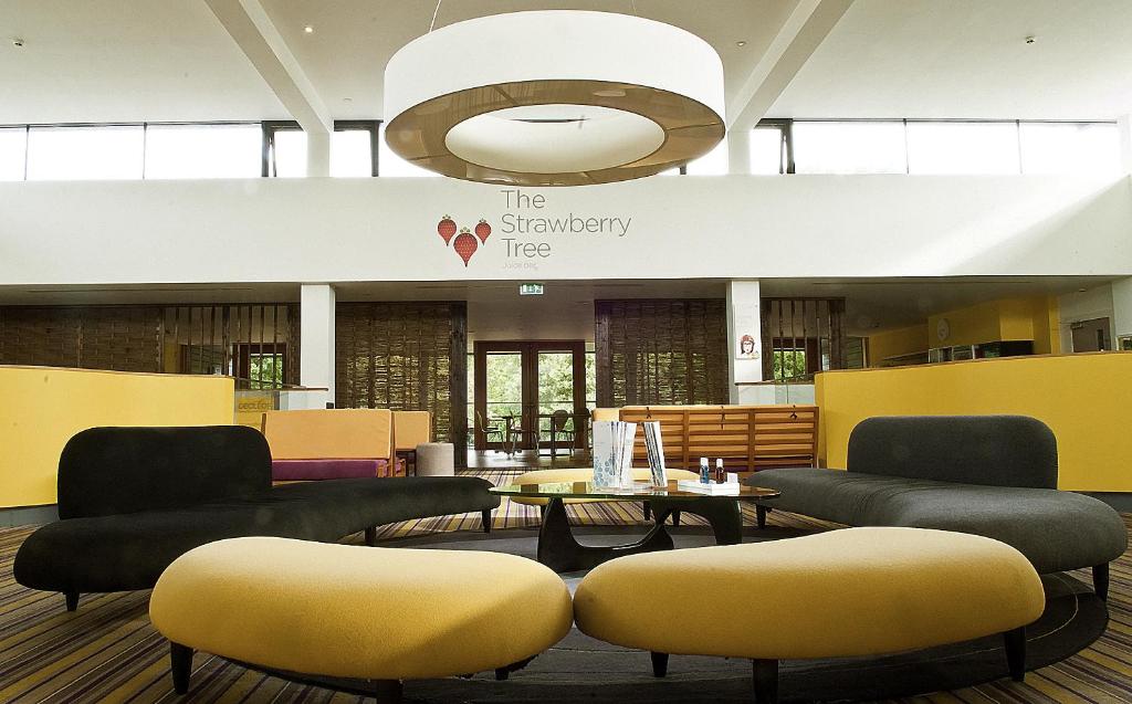 a waiting area with couches and tables in a lobby at Lifehouse Spa And Hotel in Frinton-on-Sea