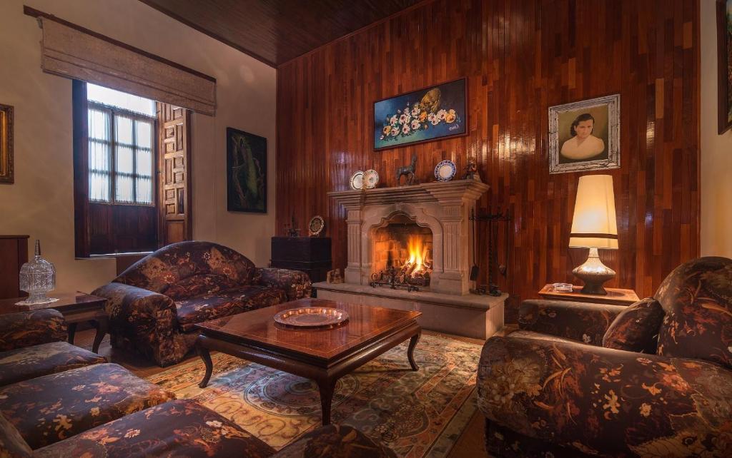 a living room with a fireplace and a table and chairs at La Casa B & B in Pátzcuaro