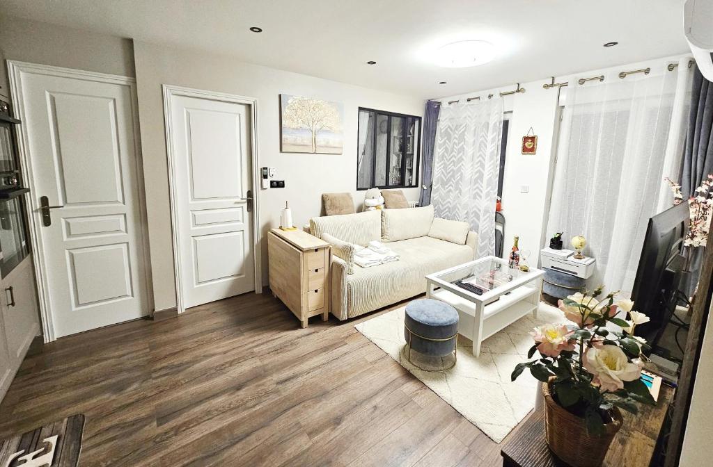 ein Wohnzimmer mit einem Sofa und einem TV in der Unterkunft Remarkable air-con 2-Bed Apartment by Paris in Le Kremlin-Bicêtre
