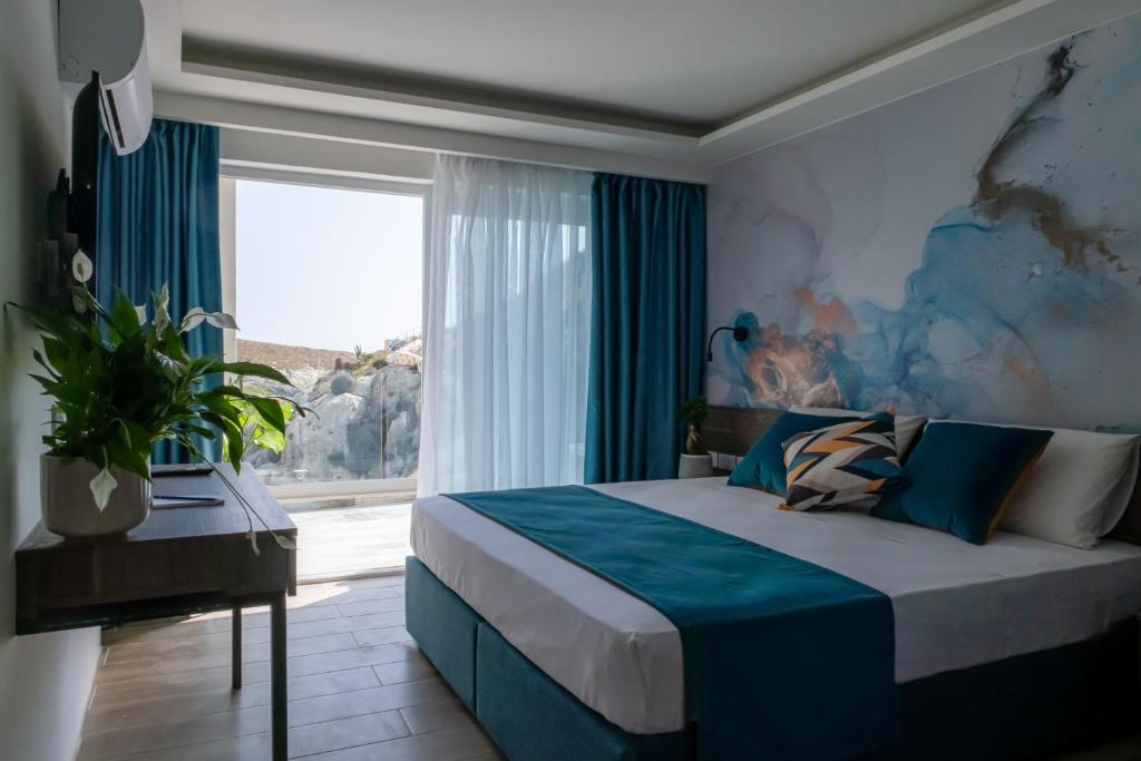 a bedroom with a large bed and a window at Blu Waters Boutique Hotel in Xlendi