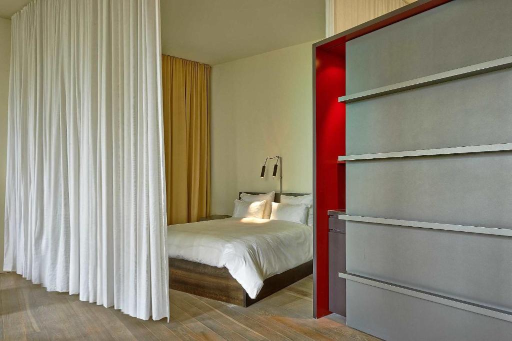a bedroom with a bed and a red wall at Sorell Hotel Rigiblick - Studios & Spa Suites in Zürich