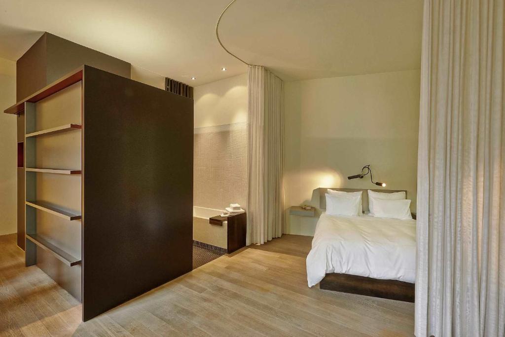 a hotel room with a bed and a book shelf at Sorell Hotel Rigiblick - Studios & Spa Suites in Zürich