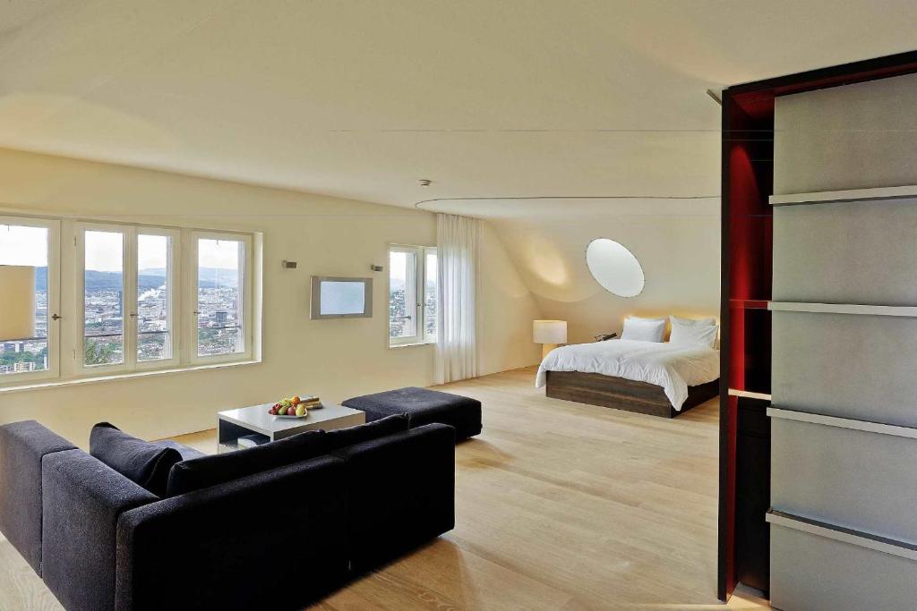 a living room with a bed and a couch at Sorell Hotel Rigiblick - Studios & Spa Suites in Zürich