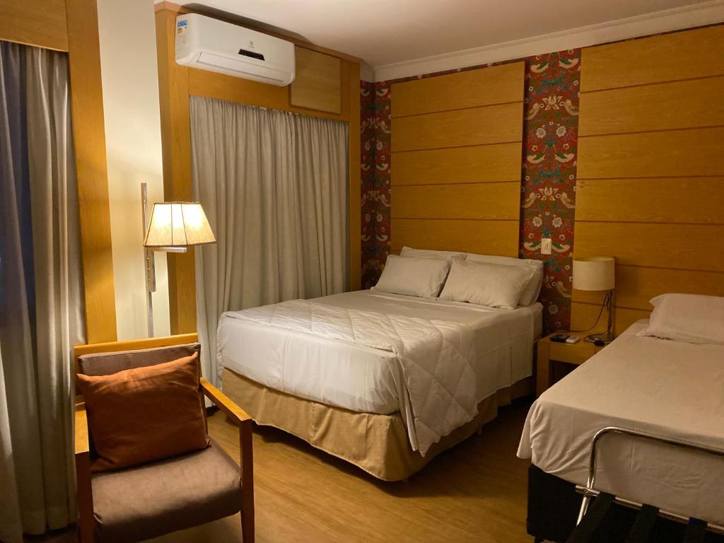 una habitación de hotel con 2 camas y una silla en Flat próximo Congonhas, en São Paulo