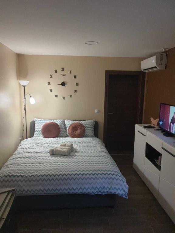 una camera da letto con un letto con un orologio sul muro di Studio apartman Alisa a Ðakovo