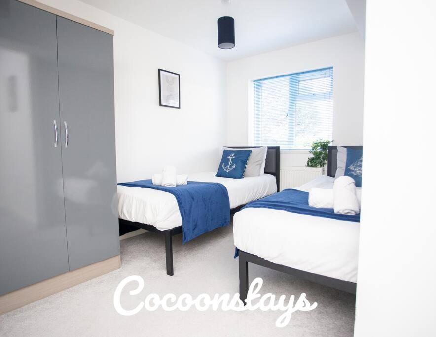 a bedroom with two beds and a window at Cocoonstays Short Lets and Serviced Accommodation Luton in Luton