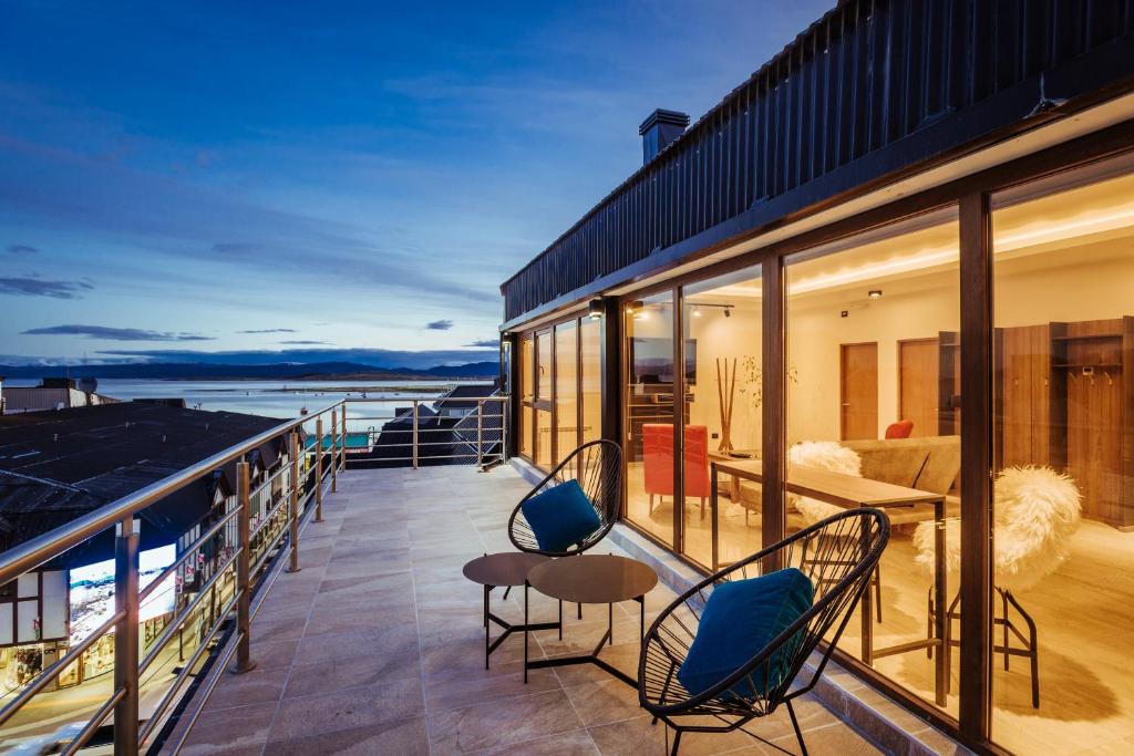 Un balcón de una casa con sillas y un sofá en Gente del Sur - Fique, en Ushuaia