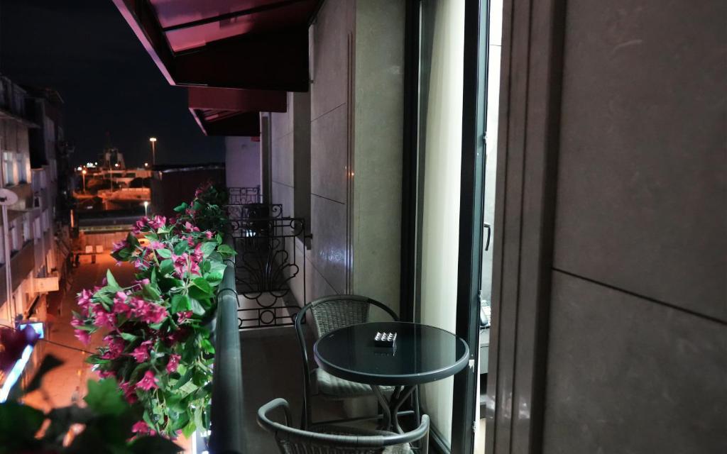 una mesa y sillas en un balcón con flores en Lux inn en Estambul