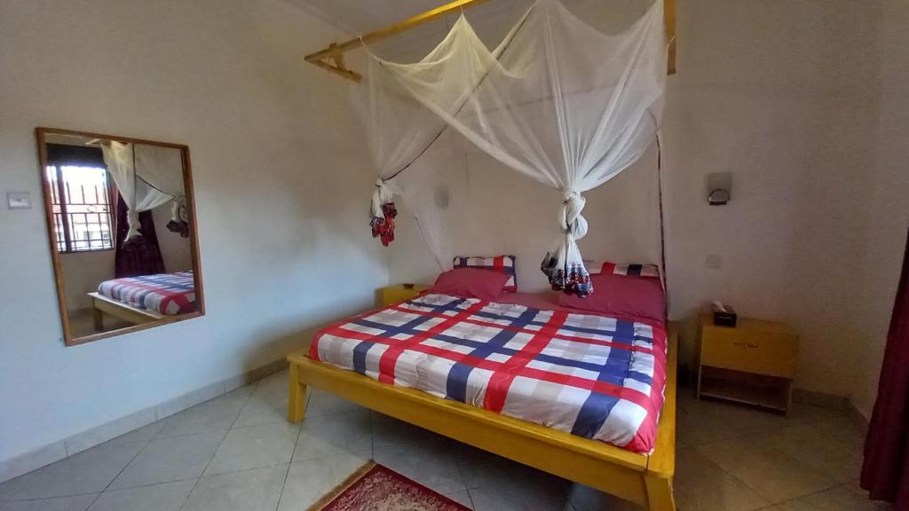 a bedroom with a bed and a mirror at Bukoto Private Room in Kampala