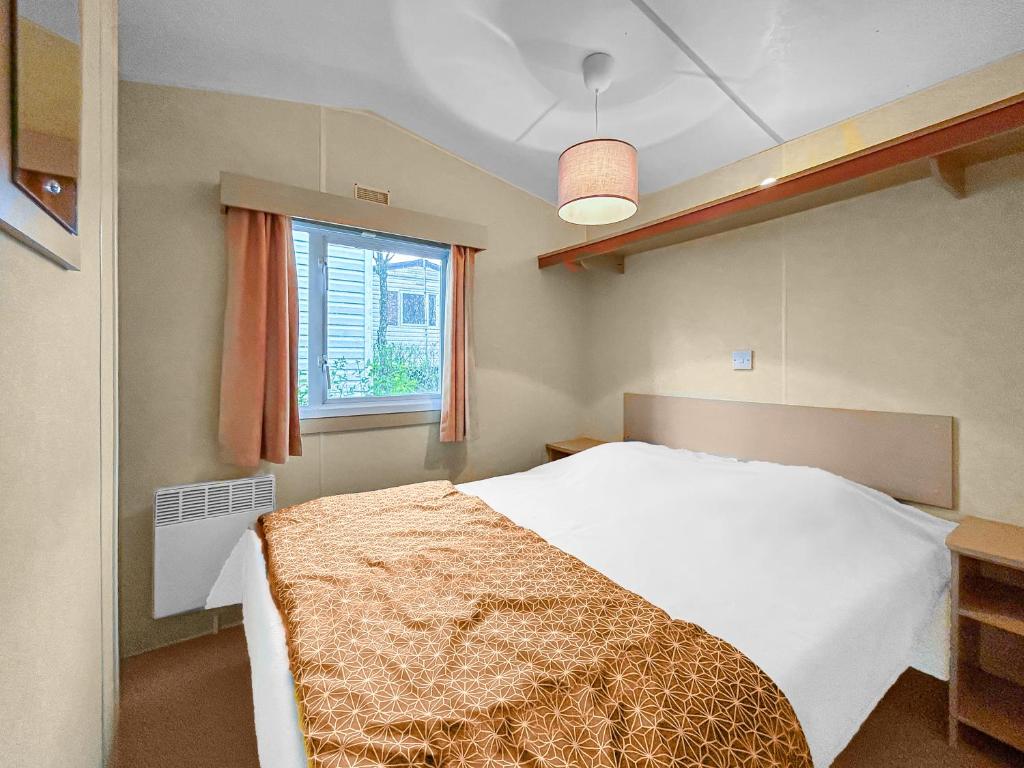 a bedroom with a white bed and a window at Pause Dordogne Ambiance Cozy à Sarlat in Sarlat-la-Canéda