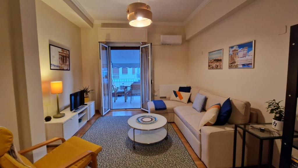 - un salon avec un canapé et une table dans l'établissement Cozy Apartment With Wrap Around Balcony, à Athènes