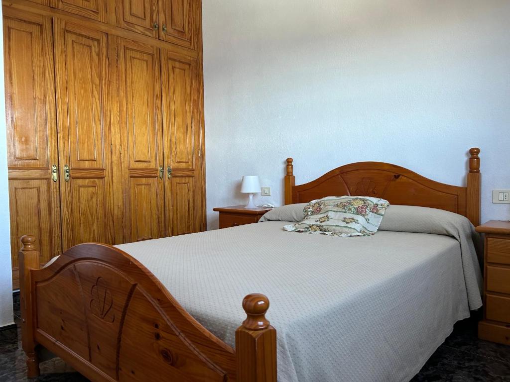 a bedroom with a wooden bed and a wooden cabinet at Pozo de las Calcosas - El Hierro in Pozo de las Calcosas